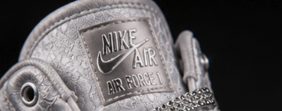 Macro of the polished metal tongue badge against embossed white leather