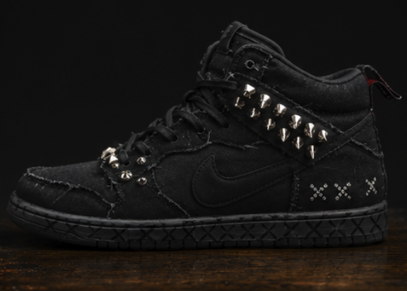Full side profile of the black high-top showing the spike run, tonal swoosh and cross-stud marks