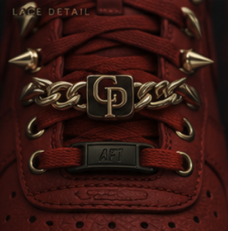 Macro of the gold GP Cuban lace charm and metal lace tag on red laces