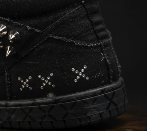 Macro of micro-stud cross marks set into the distressed black canvas quarter