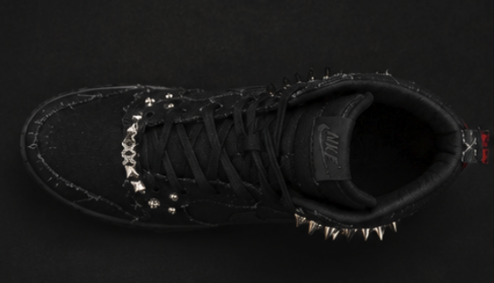 Overhead view showing the full lacing, pyramid studs and spiked collar of the black high-top